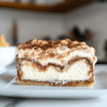 Cinnamon roll honeybun cheesecake on white marble with swirl and glaze