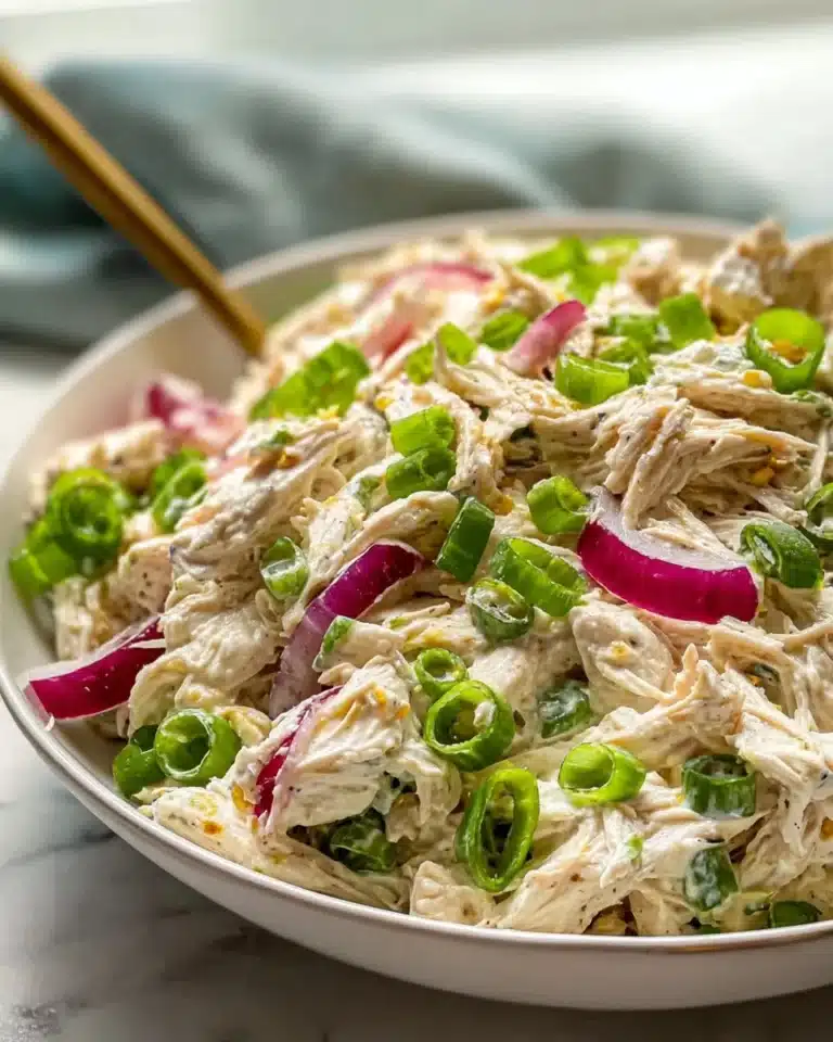 Fresh and colorful chicken salad served in a bowl with vegetables and dressing.