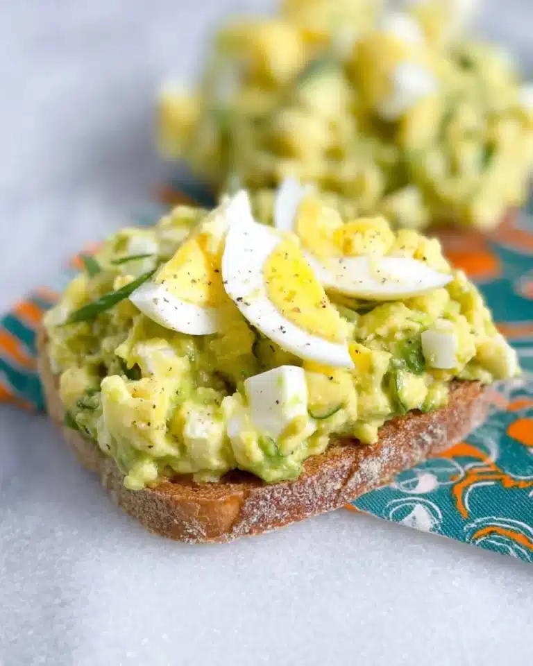 High protein avocado egg salad served in a bowl with fresh herbs
