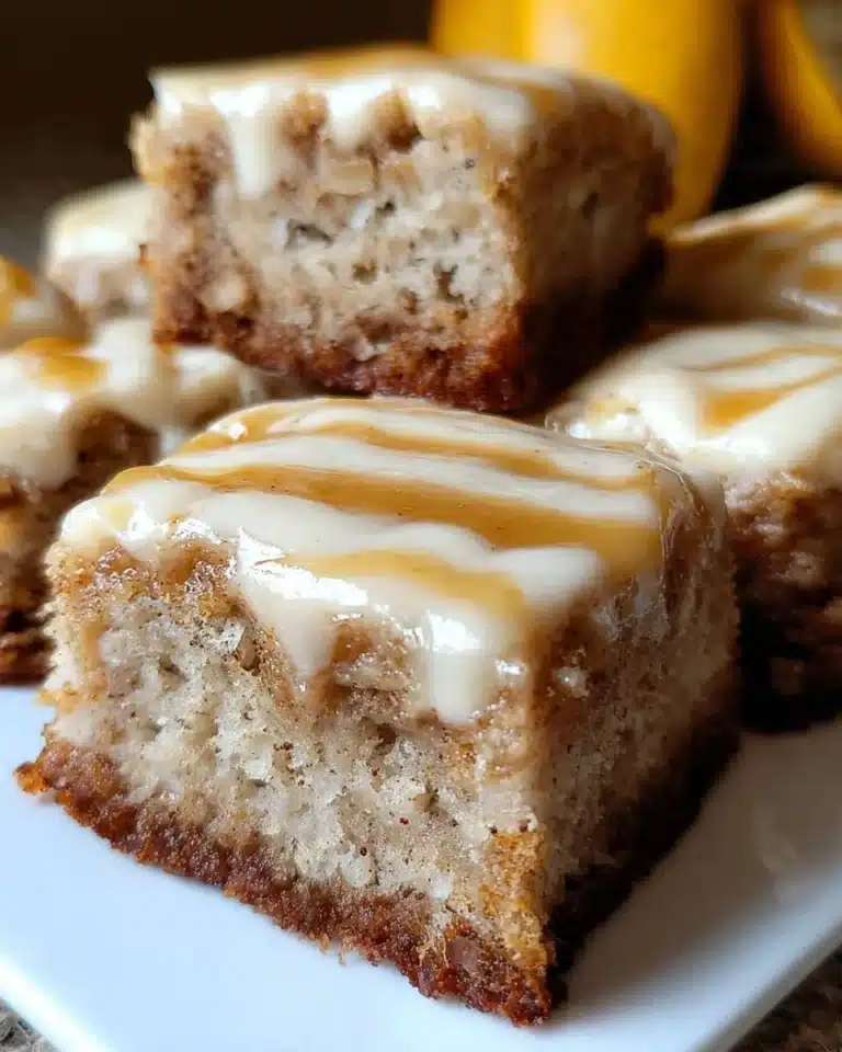 Deliciously gooey banana bars topped with frosting and sliced bananas.