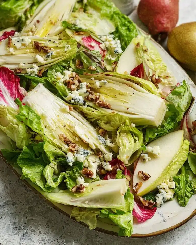 Endive salad with sliced pears and crumbled Gorgonzola cheese on a plate