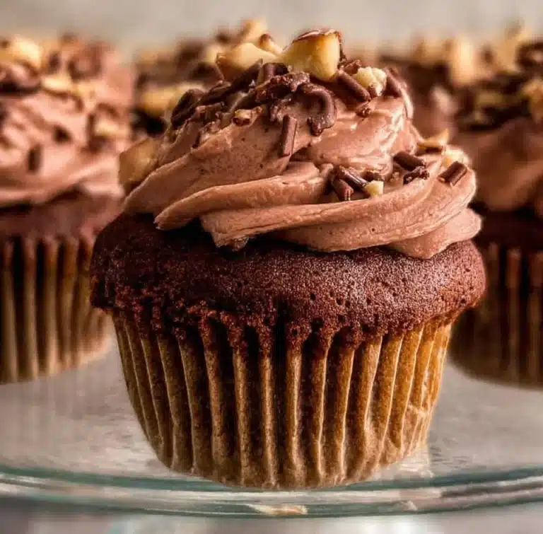 Delicious Nutella Cupcakes topped with chocolate frosting and a hazelnut garnish.