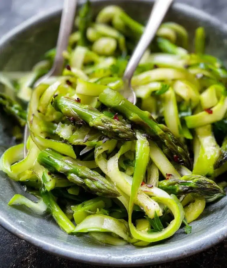 A delicious shaved asparagus salad with fresh greens and a zesty dressing.