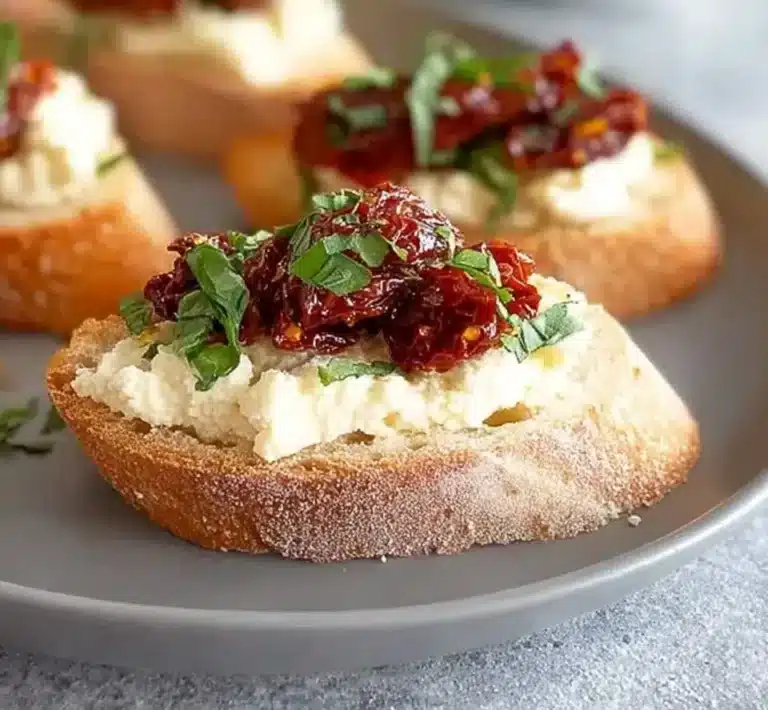 Delicious sun-dried tomato bruschetta topped with fresh basil on toasted bread.