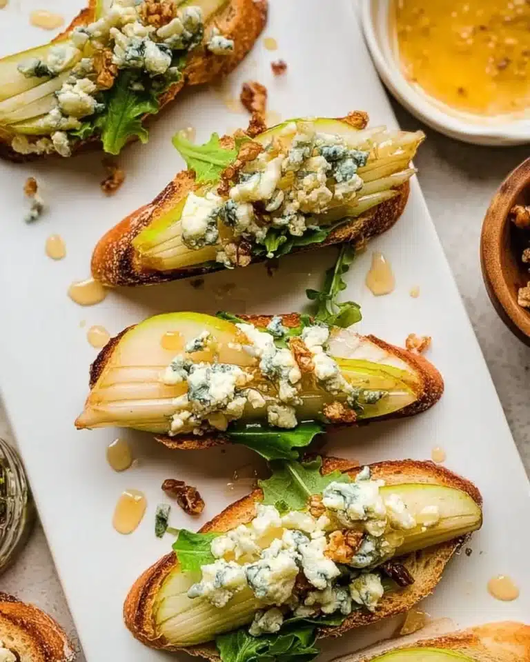 Delicious Pear and Blue Cheese Crostini topped with fresh herbs
