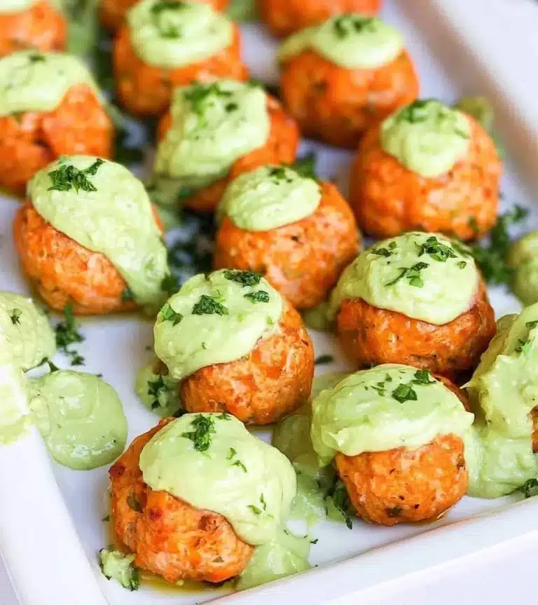 Plate of homemade salmon meatballs garnished with herbs and served with sauce