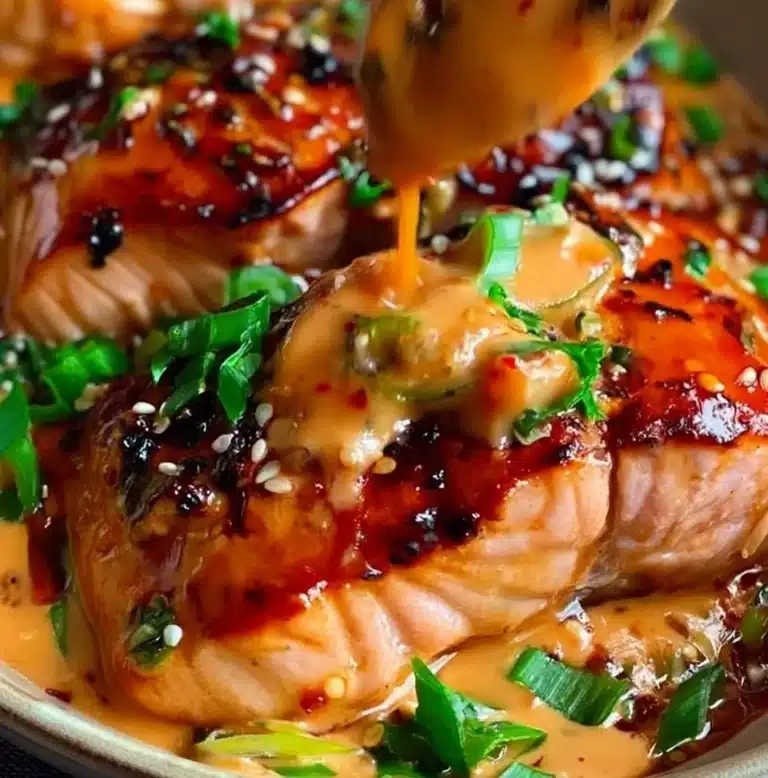 Plate of Bang Bang Salmon garnished with green onions and spicy sauce