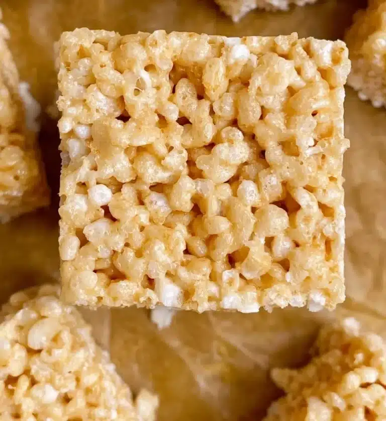 Delicious brown butter Rice Krispies treats on a wooden plate.