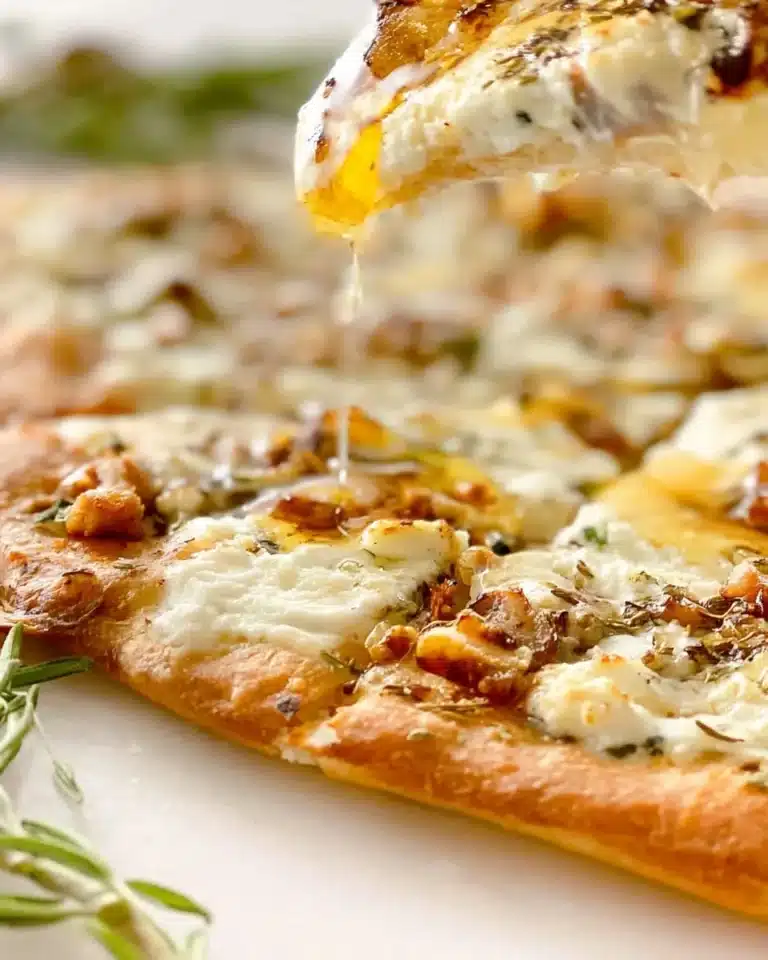 Delicious Honey Goat Cheese Pizza with honey drizzle and fresh herbs