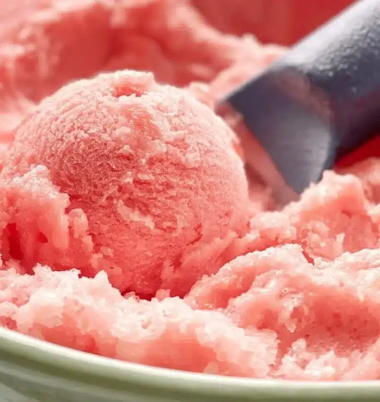 Delicious homemade watermelon ice cream in a bowl topped with mint leaves.